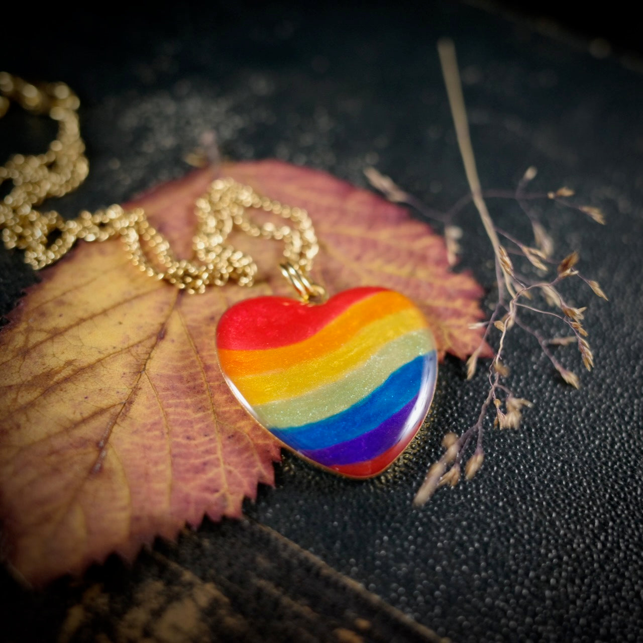 Herzanhänger in Regenbogenfarben, goldfarben – still, stark und voller Wärme