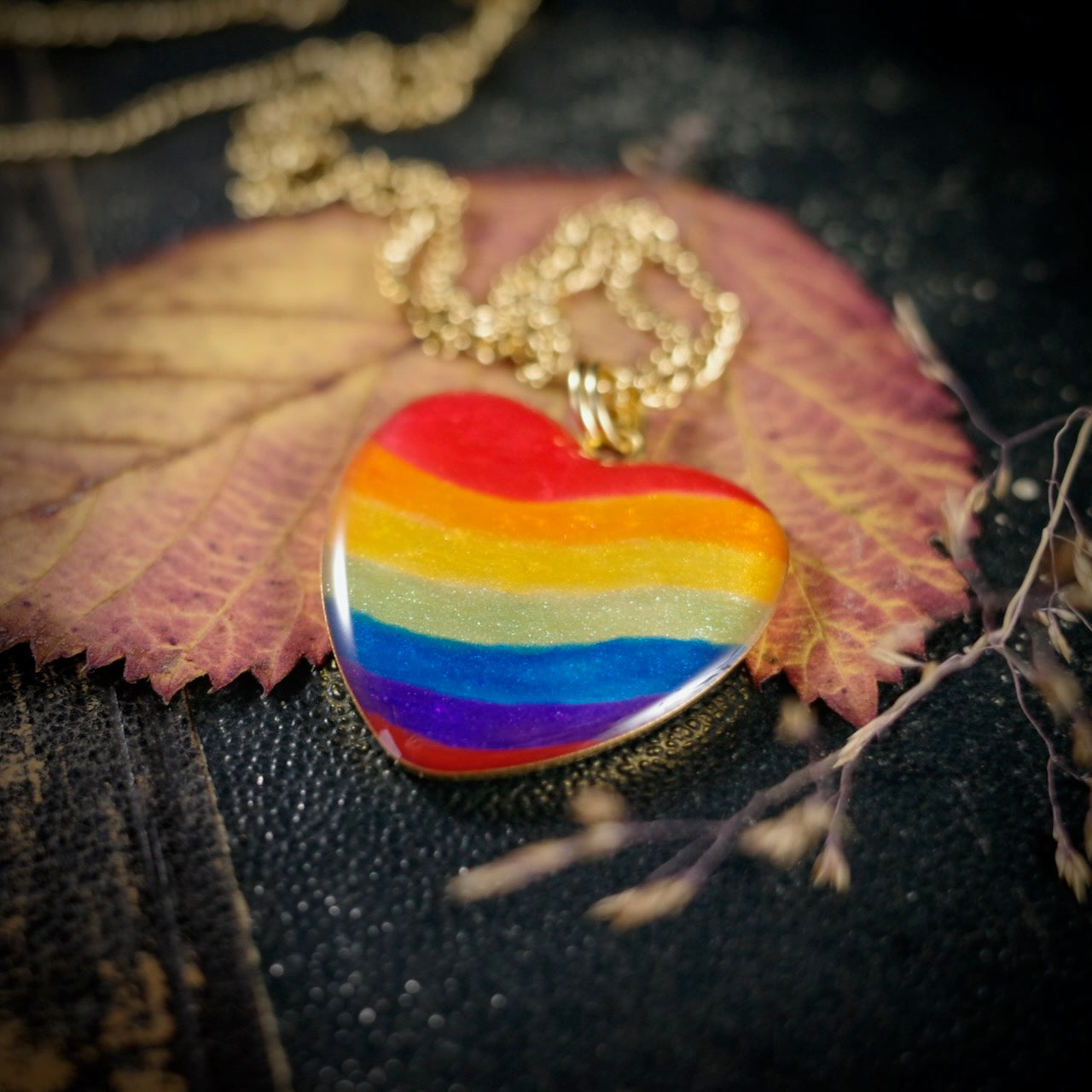 Herzanhänger in Regenbogenfarben, goldfarben – still, stark und voller Wärme